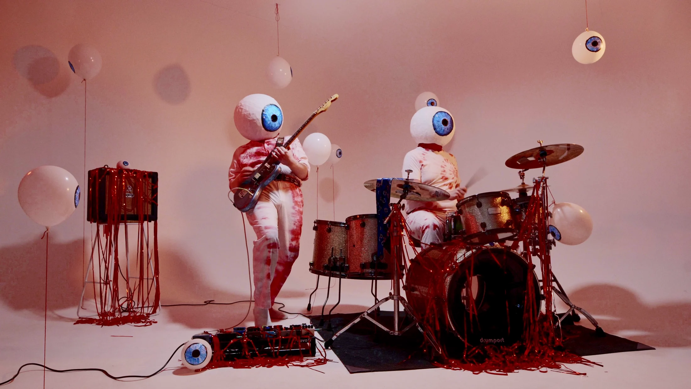 Prayers Electric performing as giant eyeball-headed figures in the Eyeballs video
