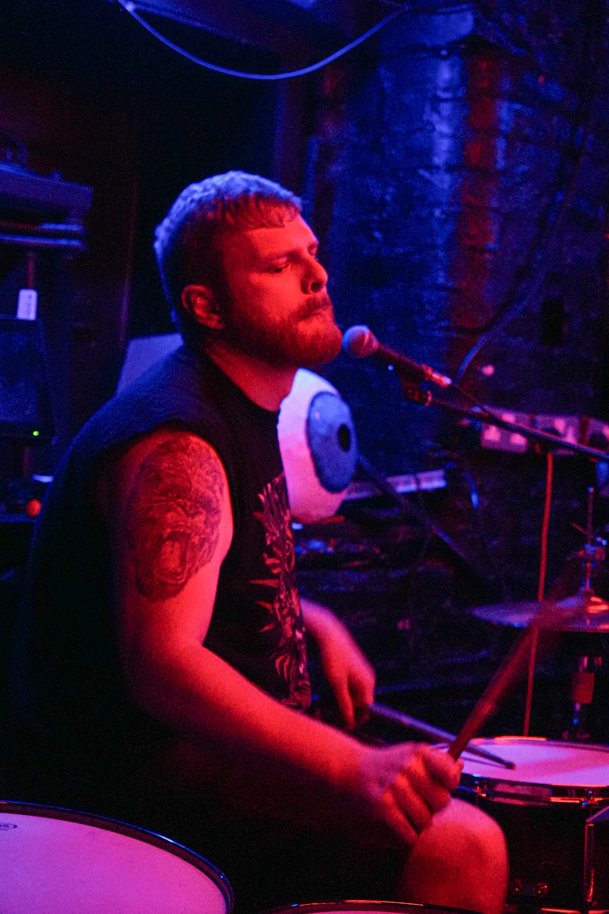 Farris singing while playing drums at Stage and Radio