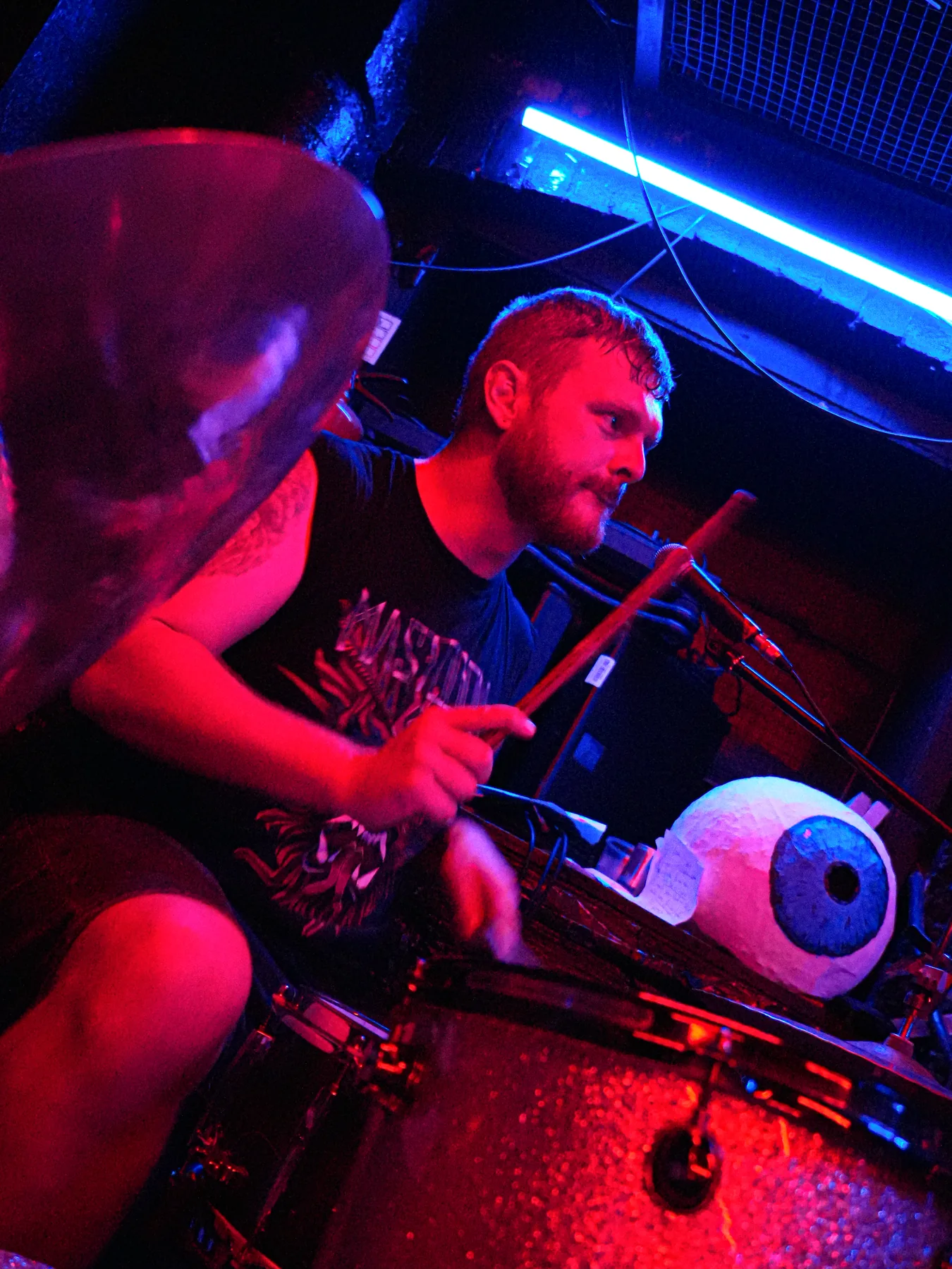 Farris playing drums beside the Prayers Electric eyeball stage prop