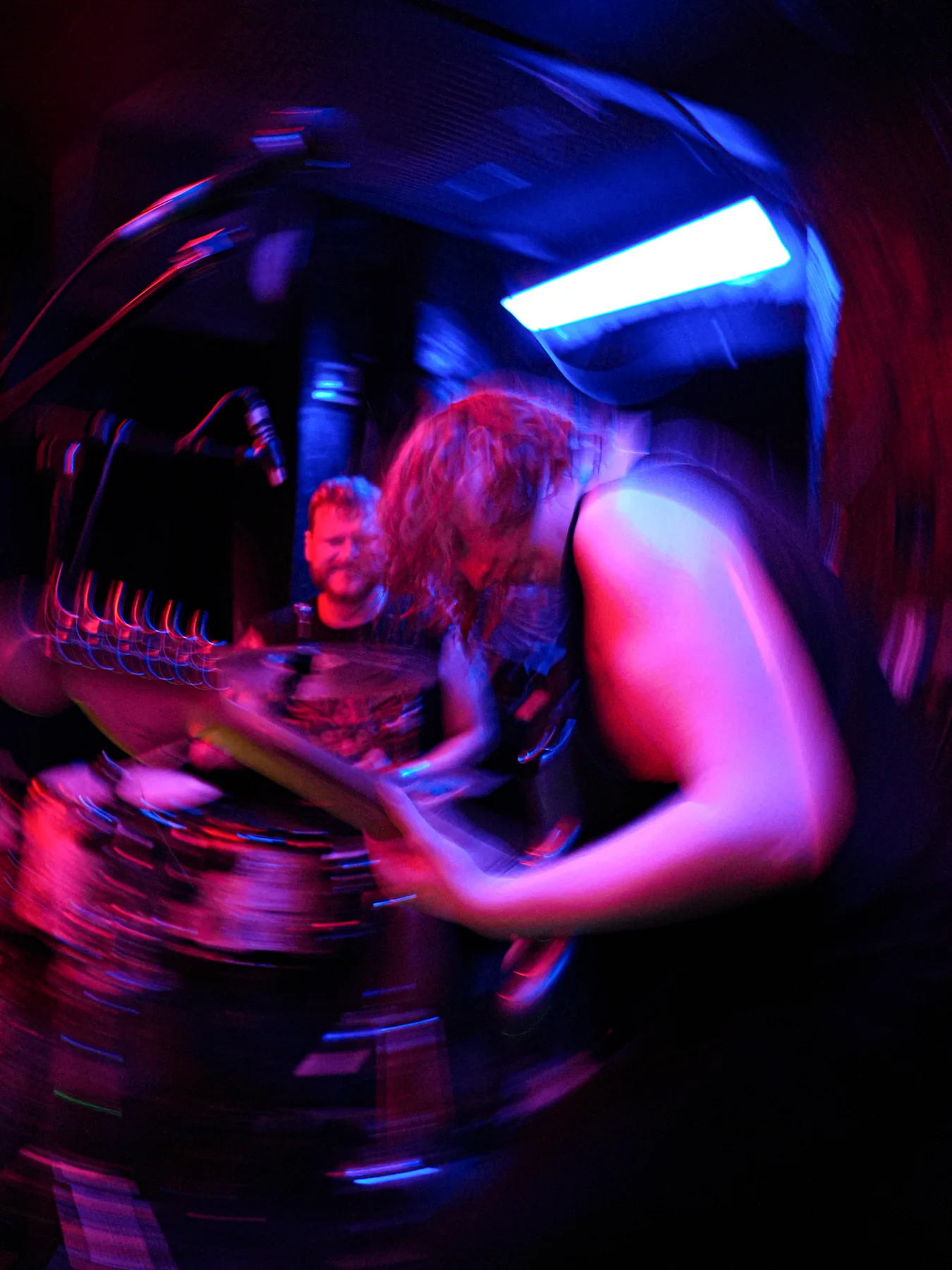 Jem playing guitar in a blur of live movement and coloured light